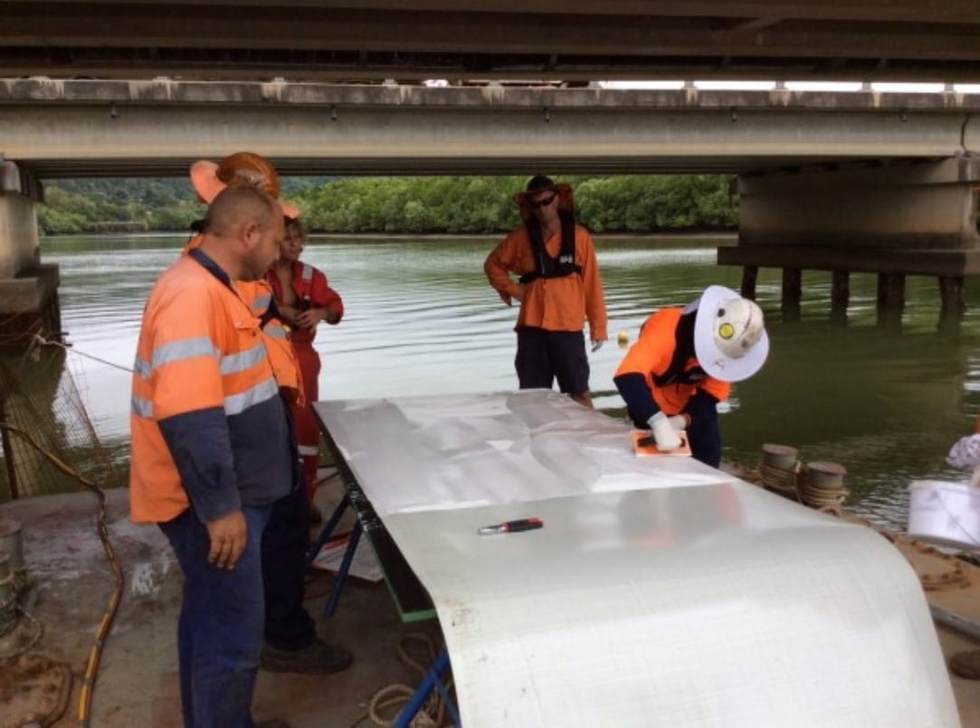 Laminate being cut to size and coated with epoxy on a barge